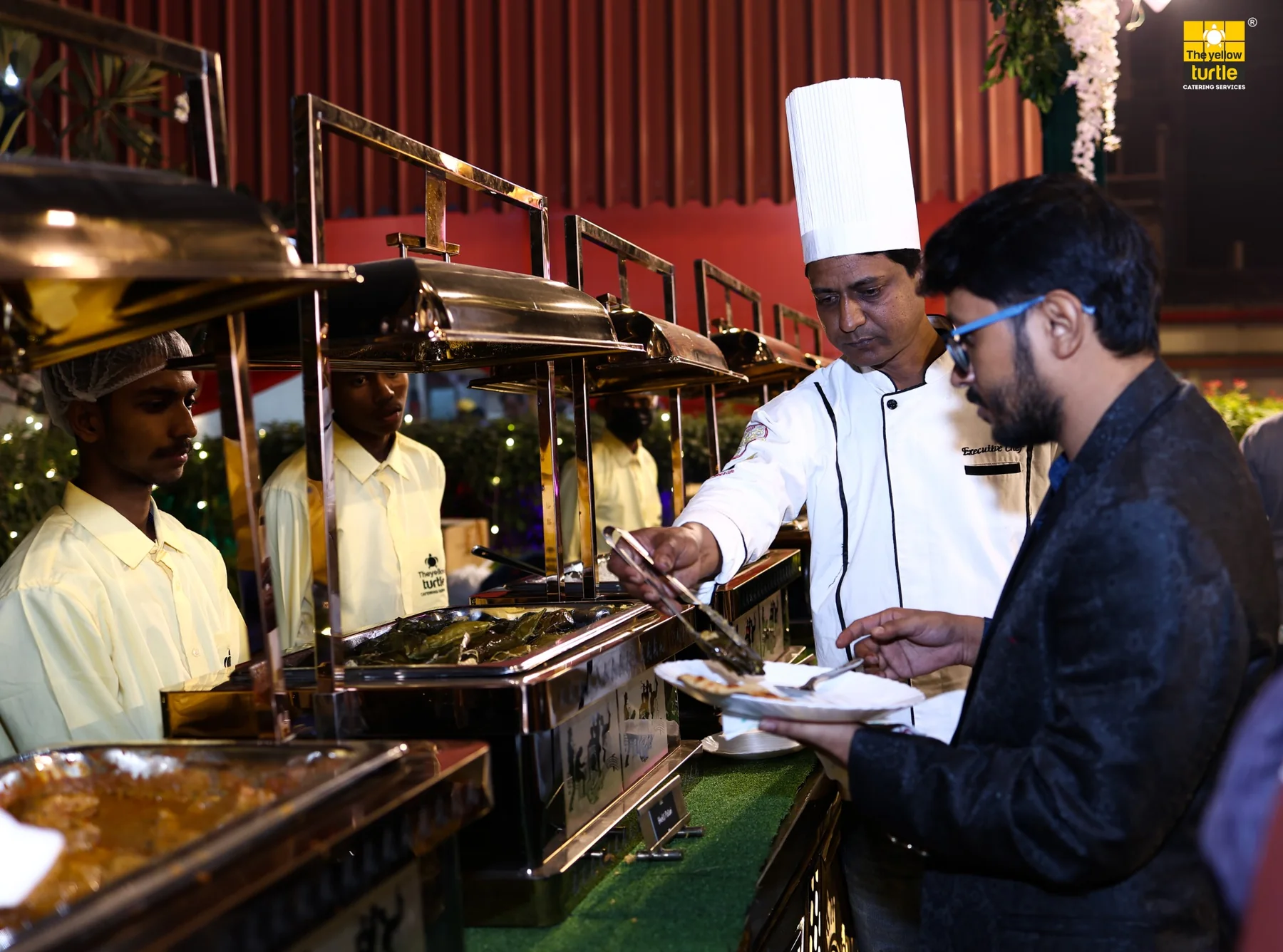 Chef serving guests at an outdoor catered event